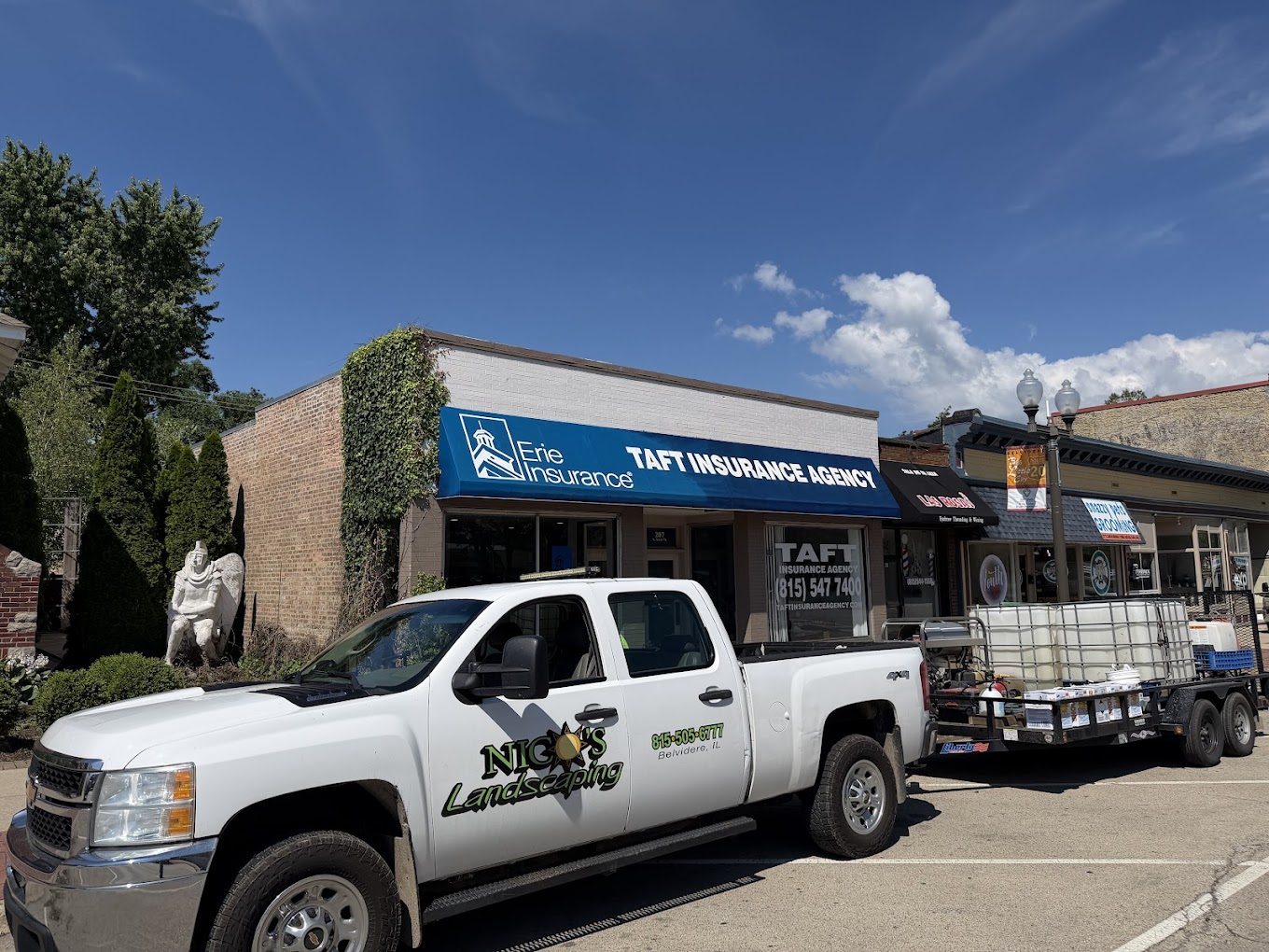 Nico's Power Washing truck and trailer parked in front of a commercial storefront job