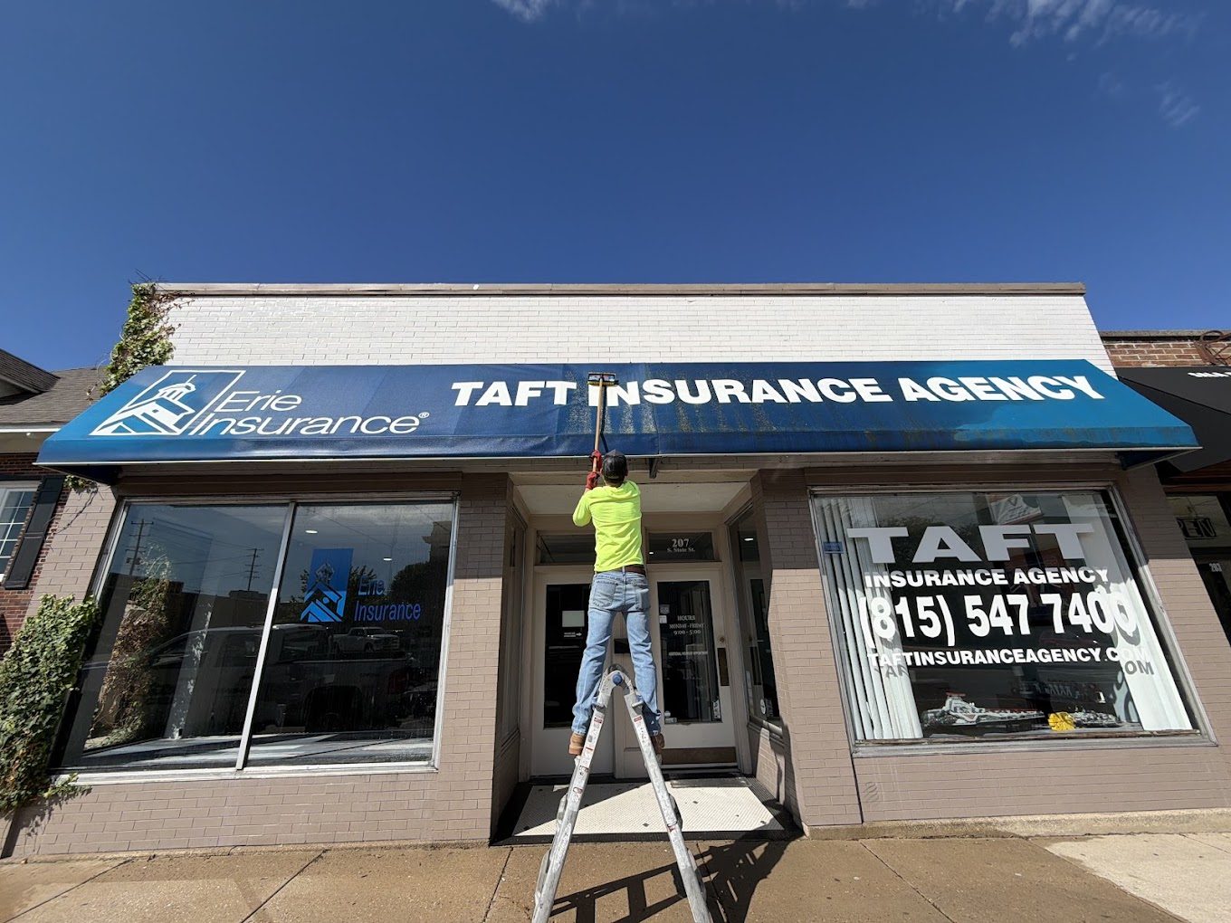 Nico's crew washing the storefront windows and awning of a downtown insurance office
