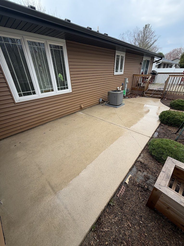 House siding and concrete patio after a full exterior wash